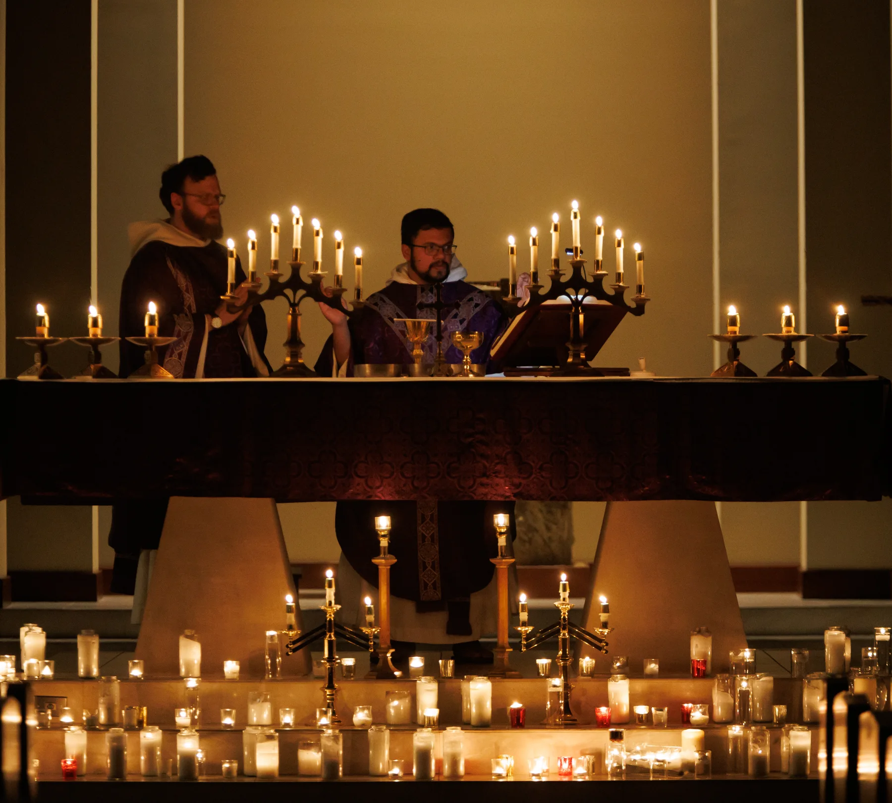 Priests at a candlelit altar