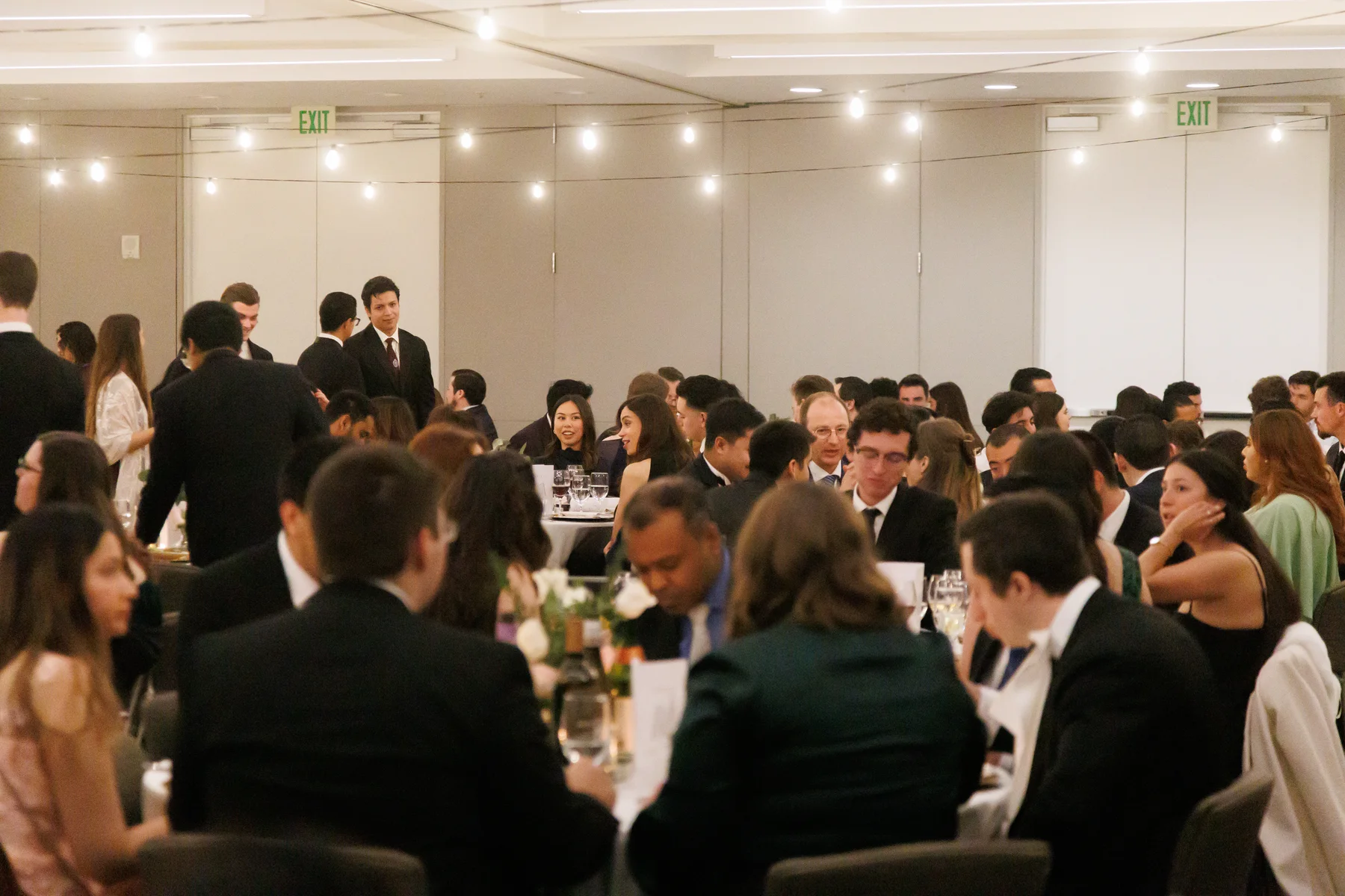 Young adults seated at tables during the fellowship dinner
